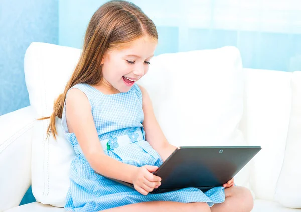 Boldog Kislány Egy Fehér Kanapén Egy Laptop — Stock Fotó