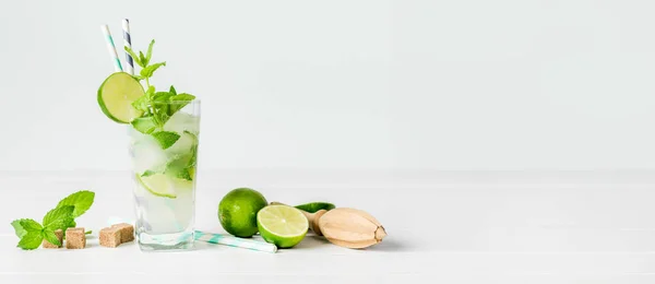 Non-alcoholic cocktail mojito with ingredients for its preparation on a white background