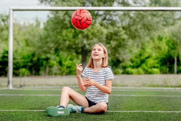 Милая Девочка Сидящая Траве Бросающая Футбольный Мяч Симпатичная Девочка Играет — стоковое фото