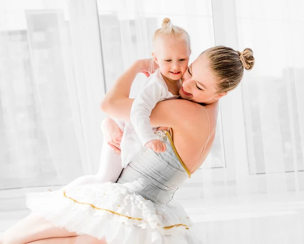 Jovem Mãe Vestido Balé Cisne Abraçando Pequena Filha Sorridente Sentada — Fotografia de Stock