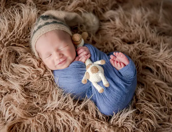 Uyurken Gülümseyen Elinde Örülmüş Zürafa Oyuncağı Tutan Sevimli Yeni Doğmuş — Stok fotoğraf