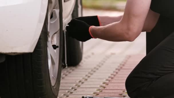 Mężczyzna Podnosi Samochód Jackiem Ulicy Jako Kierowca Zastępuje Koło — Wideo stockowe