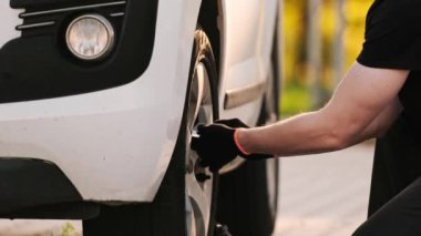 Tamirci, tekerlek cıvatasını sökmek için özenle çalışıyor