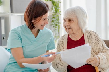 Gülümseyen Hemşire Yaşlı Kadın 'a Doktora Belgeleri Veriyor