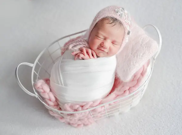 スタジオで赤ちゃんの写真セッション中にバスケットで笑顔で眠る新生児 — ストック写真