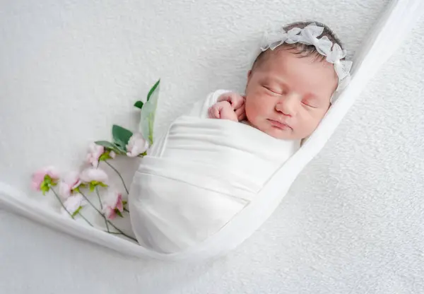 スタジオで赤ちゃんの写真セッション中にホワイトトーンでビブで眠る新生児 — ストック写真
