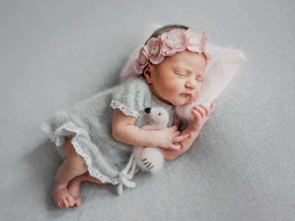 スタジオで赤ちゃんの写真撮影中にフラミンゴのおもちゃと灰色のドレスで新生児の少女が眠る — ストック写真