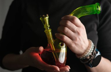 Kadın Yakın Çekimde Esrar İçtiği İçin Bong Tutuyor