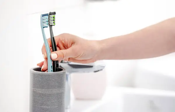 Girls Hand Places Two Toothbrushes Cup Marking Start Couples Life — Stock Photo, Image