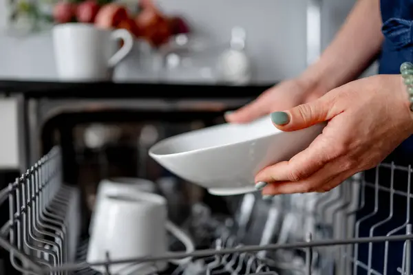 stock image Girl Retrieves Clean Plate From Dishwasher In Close-Up View