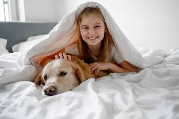 Dziewczyna Leży Pod Kocem Jej Golden Retriever Dog — Zdjęcie stockowe