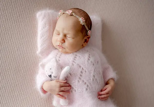 ピンクのスーツの新生児は プロの新生児の写真撮影中にトイキャットと眠る — ストック写真