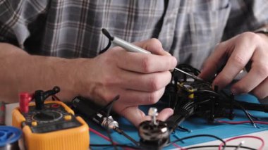 FPV hobi insansız hava aracının kablolarını ve mikroçip panosunu tamir eden tamirci.