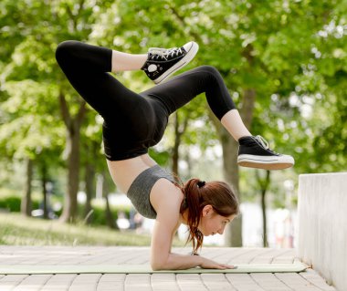 Kız jimnastikçi yaz boyunca Park 'ta Akrobatik Egzersizleri Yapıyor