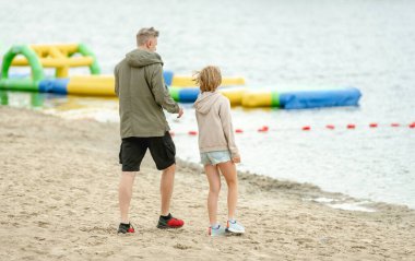 Baba ve kızı göl kıyısında baharın tadını çıkarıyorlar.