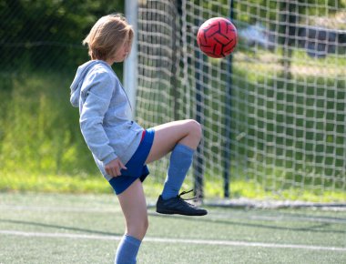 Futbol antrenmanı sırasında Ayağı Yakın Topa Tekmeleyen Çocuk