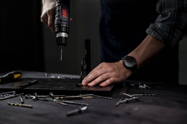 Usta sondaj deliğiyle delik açıyor, rafı yapmak için, Eller yakın plan