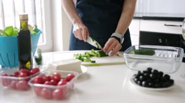 Mutfakta Bir Kadın Yunan Salatasını Hazırlayan Salatalıkları Kesiyor