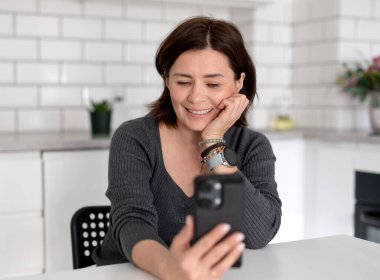 Evde Konuşan Genç Kadın Telefondaki Video Görüşmesi