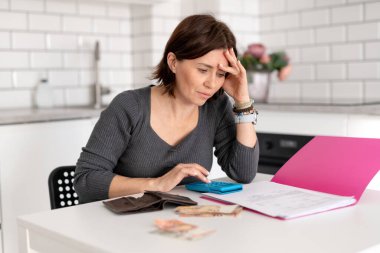 Genç kadın evdeki mali sorunlarla ilgilenen faturaları hallediyor.
