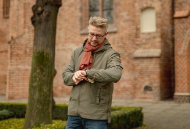 Çekici adam gezintiye çıkıyor ve gezi zamanını kontrol ediyor.