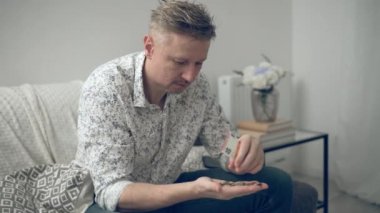 Genç adam para sayıyor ve ardından evde madeni paralar ve banknotlar