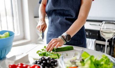 Mutfakta Bir Kadın Yunan Salatasını Hazırlayan Salatalıkları Kesiyor