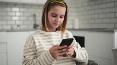 İnternette akıllı telefondan sörf yapan ve arkadaşlarıyla sohbet eden sevimli küçük bir kız.