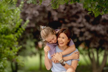 Anne ve kızı mutlu bir şekilde birlikte eğleniyorlar.