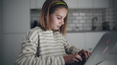 İnternette ve sosyal medyada dizüstü bilgisayarda sörf yapan ve arkadaşlarıyla sohbet eden sevimli küçük bir kız.