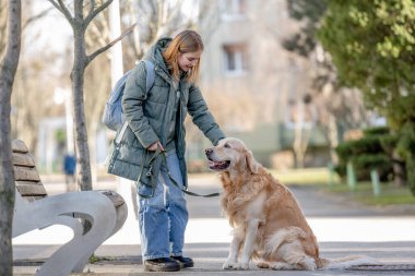 Golden Retriever köpekle kış yürüyüşü sırasında genç sahibine patisini veriyor.