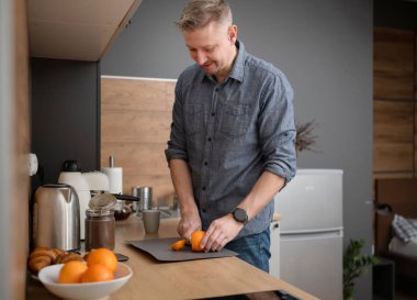 Mutfakta portakal kesen mutlu adam.