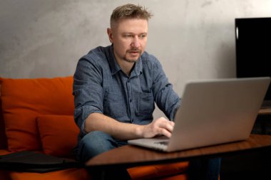 Evdeki bilgisayarla uzaktan çalışan bir adam.