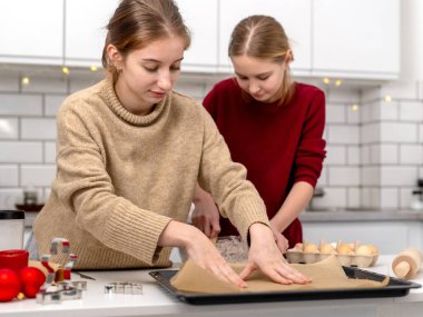 Kız kardeşler mutfakta zencefilli ekmek yapıyor.