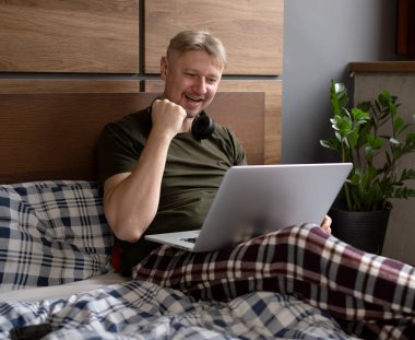 Mutlu Adam evde dizüstü bilgisayar kullanıyor.