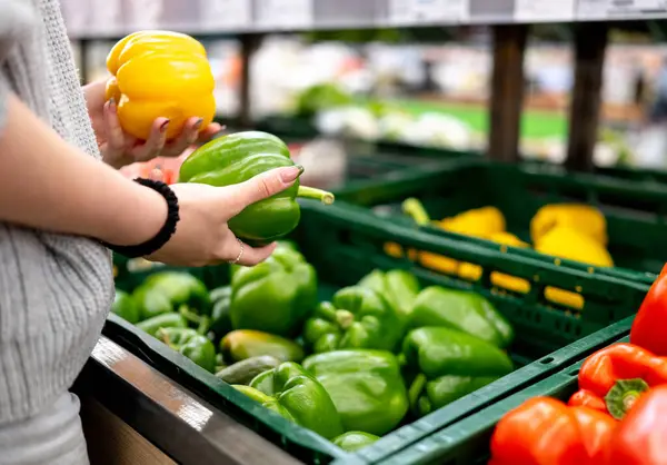 Süpermarkette biber seçen bir kız.