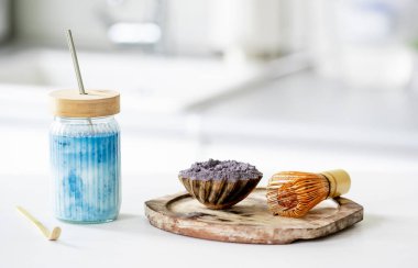 Hazırlığı için aksesuarlı bir içecek kavanozunda mavi buzlu kirazlı latte.