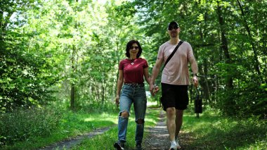 Genç çift ormanda gezintiye çıkıyor.