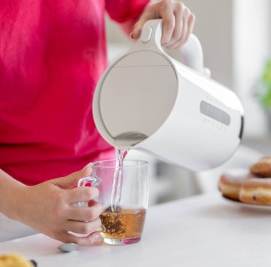 Poşetten çay yapan bir kadının yakın çekimi.