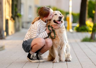 Mutlu kız dışarıda Golden Retriever Dog 'a sarılıyor