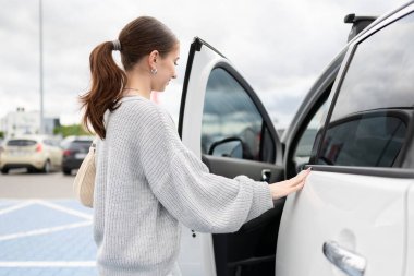 Park alanında direksiyon başına geçen genç bir kadın.