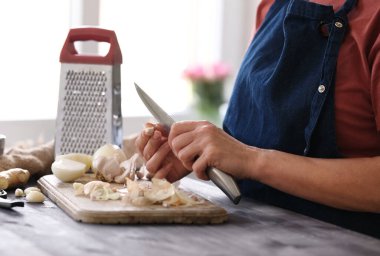 Mutfakta sarımsak temizleyen kadın.