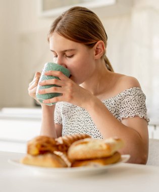 Teen Girl Drinking Tea In The Kitchen At Home