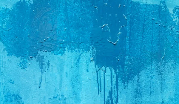 Bright blue painted wall texture with stains and smudges