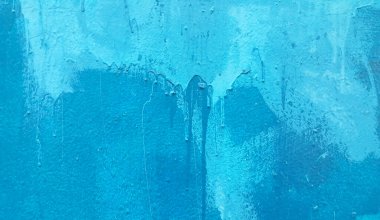 Bright blue painted wall texture with stains and smudges