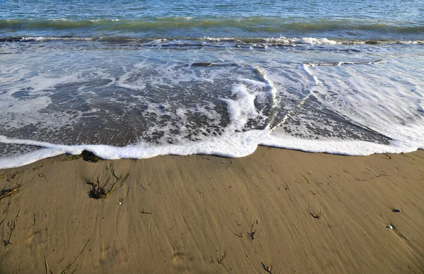 海岸沙滩上有白色泡沫的海浪 自然特写背景 — 图库照片