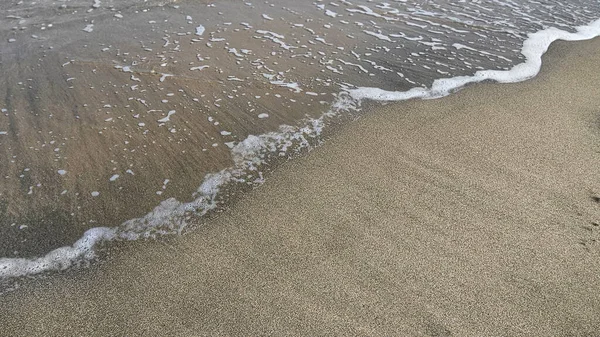 砂の上に透明な海の波 自然の背景を閉じます — ストック写真
