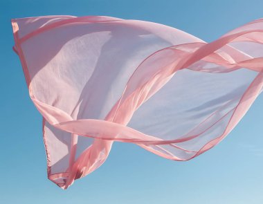 Mavi zemin üzerinde pembe şeffaf kumaş dalgası uçuyor ve güneş ışığıyla aydınlatılıyor, dalgalı ipek kanat çırpıyor.