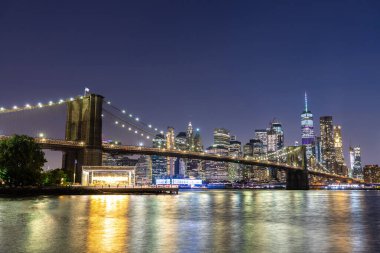 Brooklyn Köprüsü ve Manhattan şehir merkezinin panoramik gece görüntüsü New York City, ABD 'de gün batımından sonra