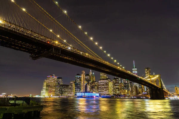 布鲁克林大桥和美国纽约市日落后的曼哈顿市中心全景夜景 — 图库照片